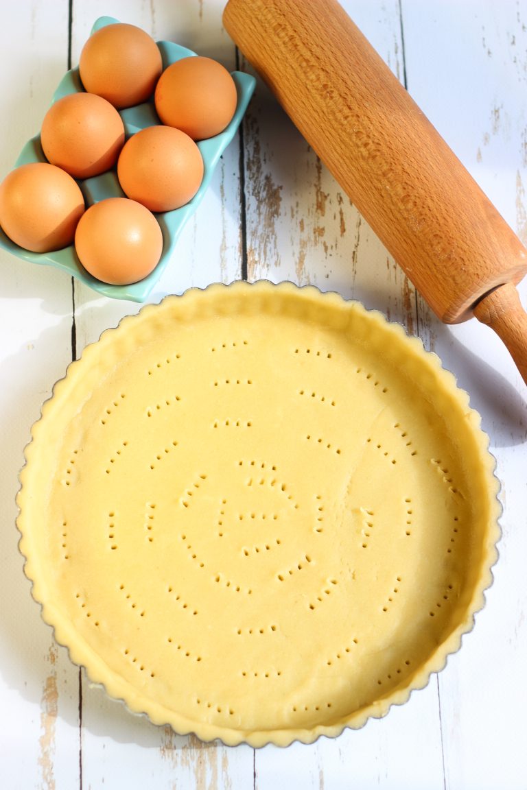 Homemade sweet tart dough pressed into a fluted tart pan, pricked with a fork, and ready to bake.