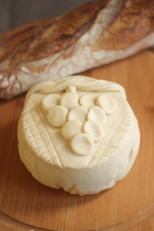 Before baking:
Camembert wrapped in puff pastry and decorated with a grape design made from pastry scraps before baking.