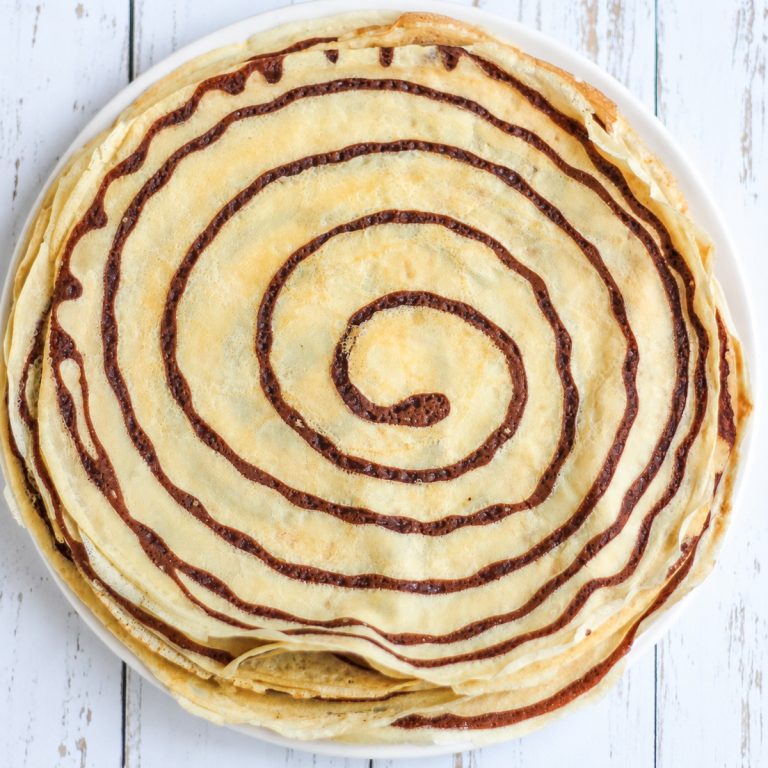 Overhead view of a stack of homemade French crepes with chocolate swirls